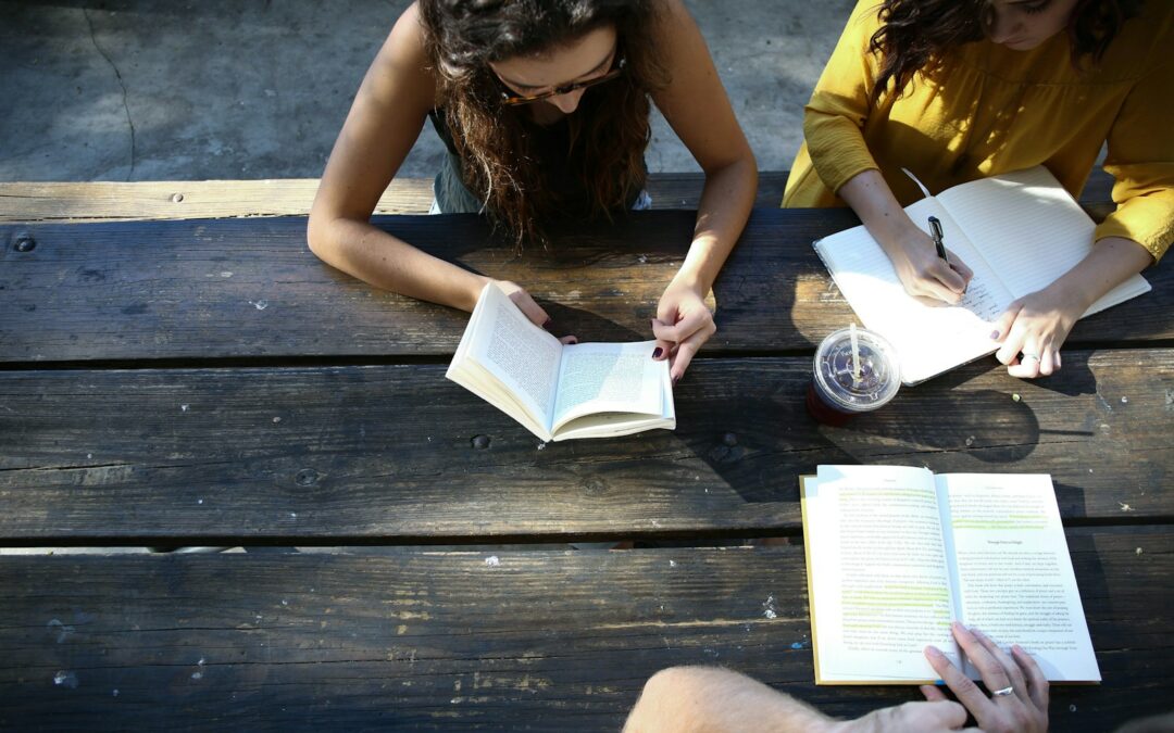woman reading book while sitting on chair